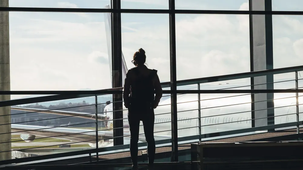 woman looking out airport window.